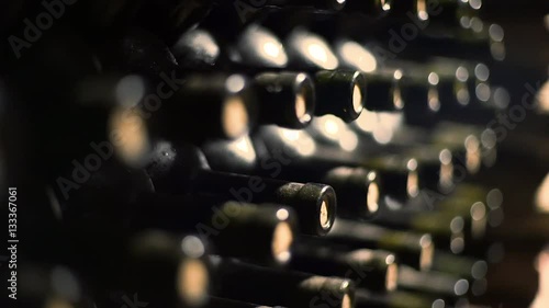 wine bottles stacked in a cellar with shallow depth of field
