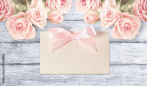 Fotografie Roses with paper card on background of shabby wooden planks.