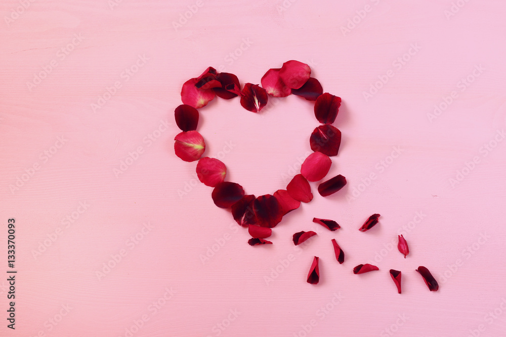 Top view of red rose petals making heart shape
