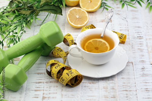 ginger tea - fitness liefestyle concept with tea, dumbells and measure tape photo