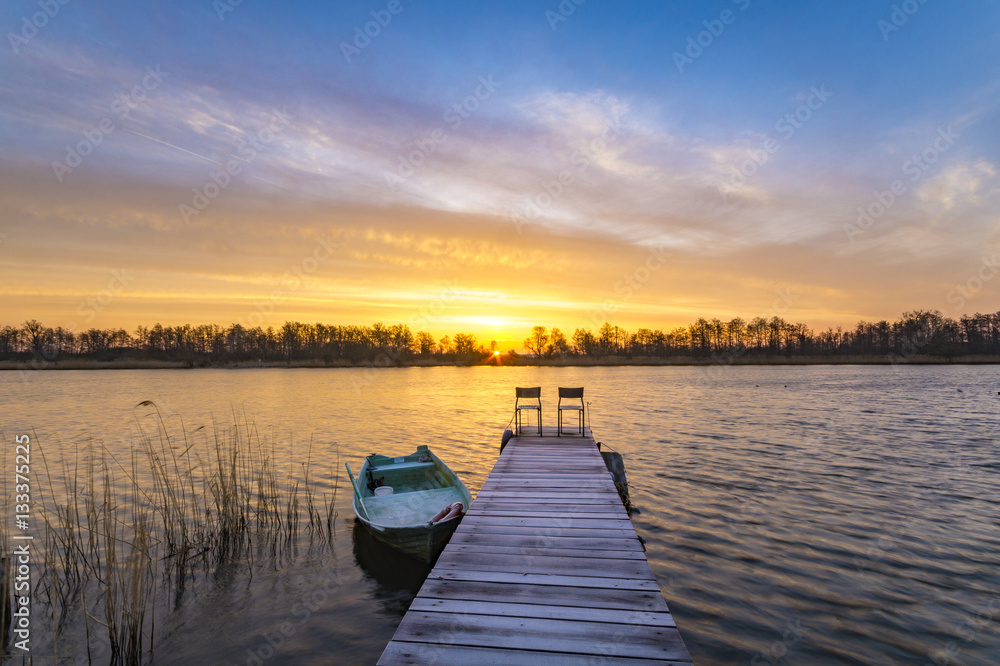 boat moored to a wooden bridge, a beautiful sunrise over the lak boat moored to a wooden bridge, a beautiful sunrise over the lak