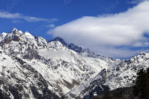 Snow winter mountains and blue sky with clouds at sun day © BSANI
