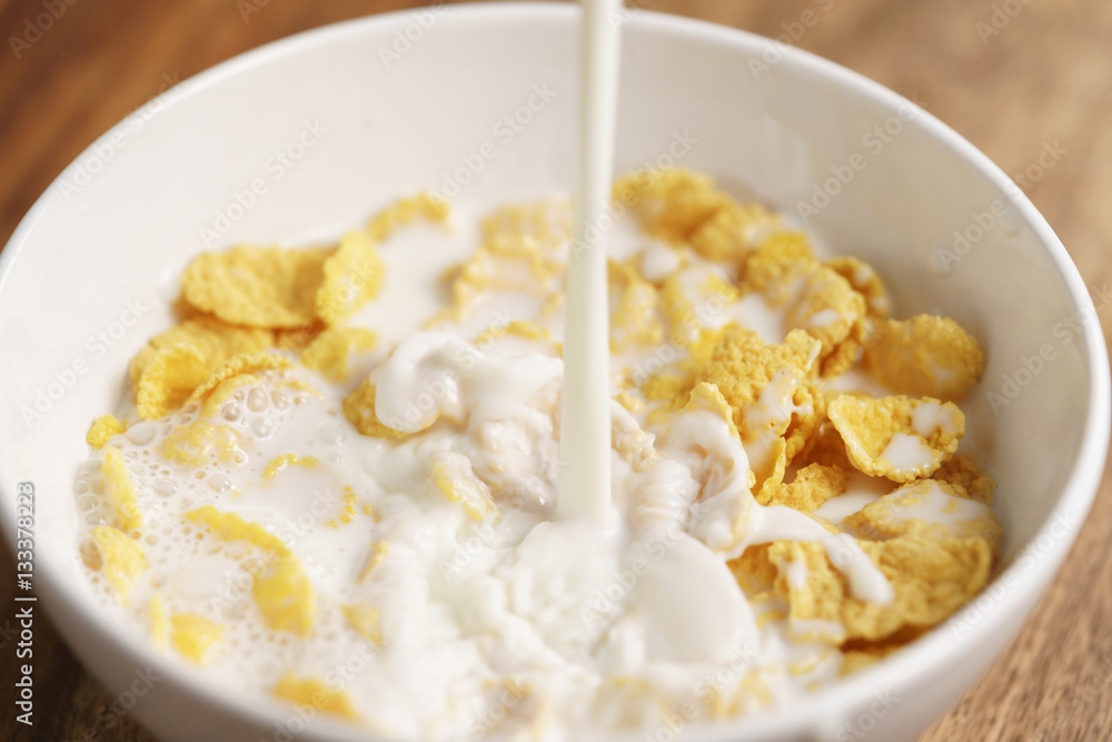 milk pour into bowl with corn flakes, preparing breakfast milk pour into bowl with corn flakes, preparing breakfast