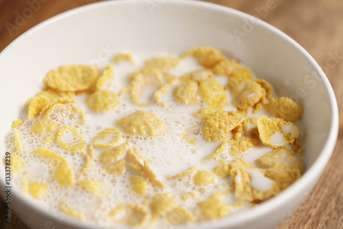 corn flakes with milk in white bowl, simple healthy breakfast