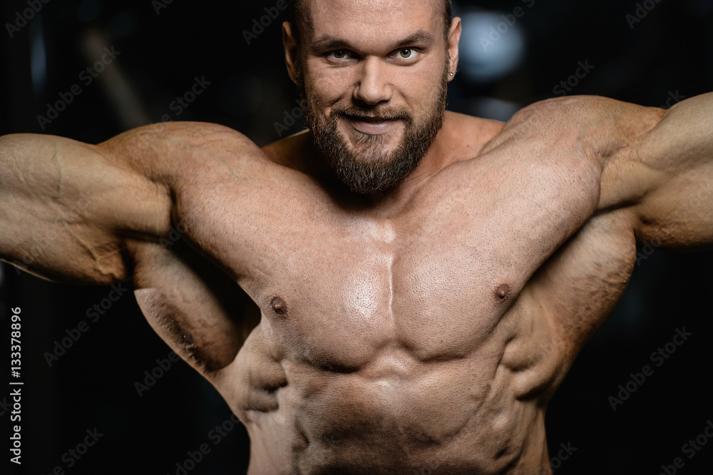 Fototapeta premium Brutal strong bodybuilder athletic men pumping up muscles with d