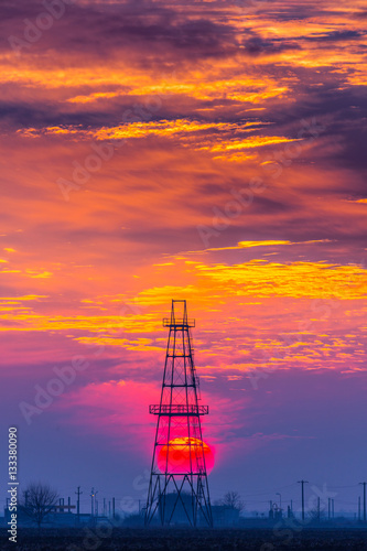Oil and gas rig profiled on sunset sky