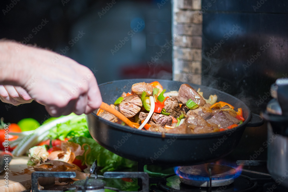 Man mixing the meat in a frying pan shovel