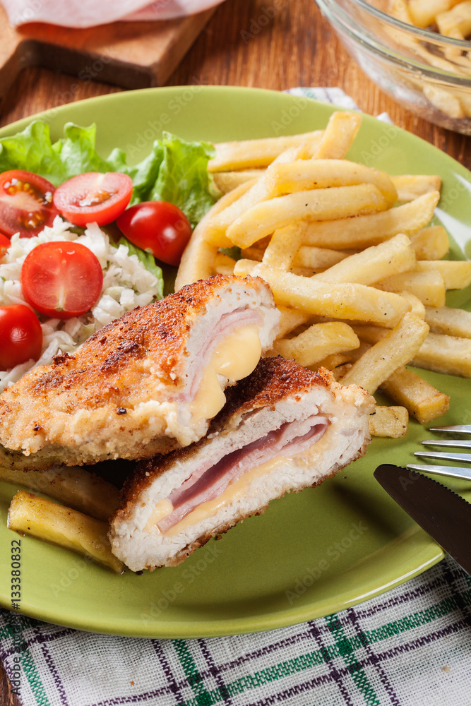 Cutlet Cordon Bleu with pork loin served with French fries and salad Cutlet Cordon Bleu with pork loin served with French fries and salad