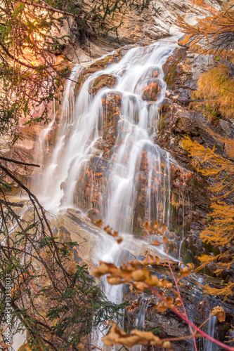 waterfall in autumn with trees and warm autumn colors. Trees in autumn with yellow colors
