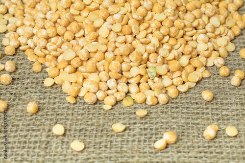 Top view of Dry yellow split peas chickpeas on burlap texture ba