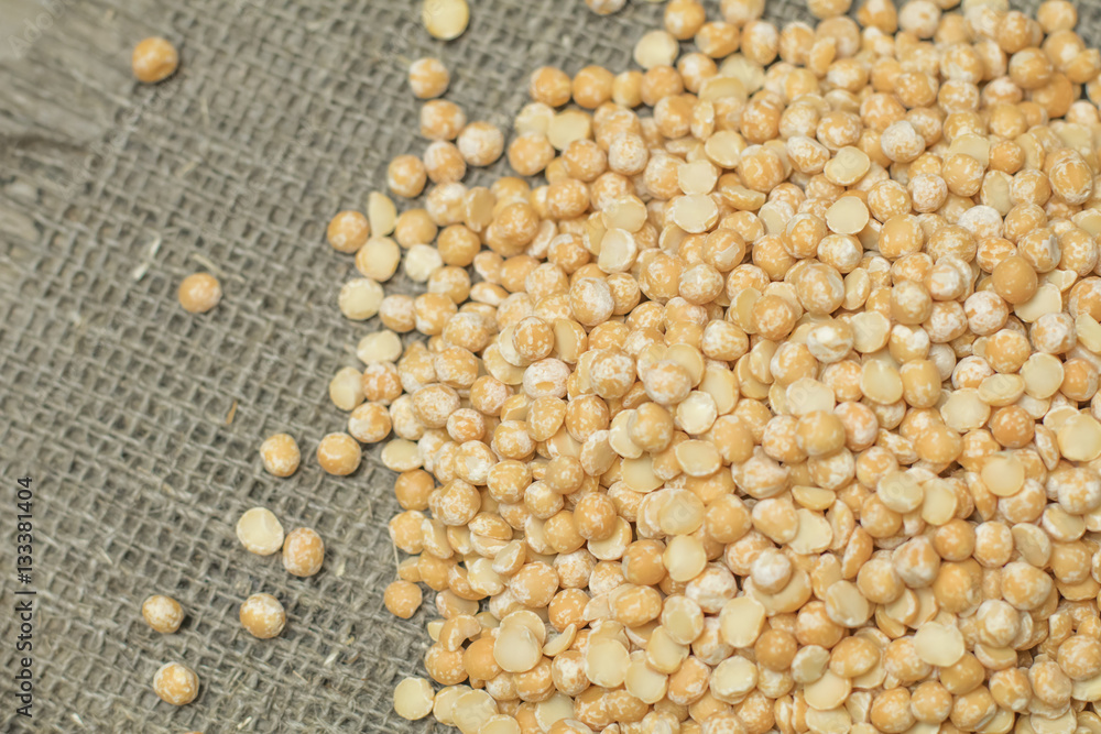Top view of Dry yellow split peas chickpeas on burlap texture ba Top view of Dry yellow split peas chickpeas on burlap texture ba
