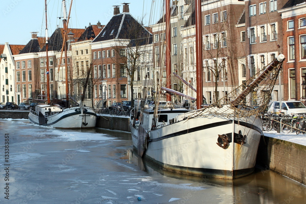 Φωτογραφία Boats in a frozen canal and historic houses in the city of Groningen