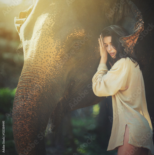 beautiful young woman posing with happy elephant