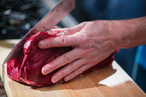 The knife cuts a piece of meat in half
