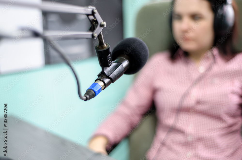 A radio DJ announces news in a radio-studio
