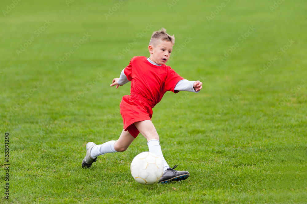 Young blonde soccer player in solo action