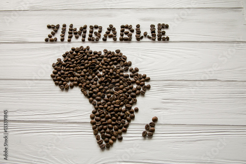 Map of the Africa made of roasted coffee beans  on white wooden textured background with space for text
