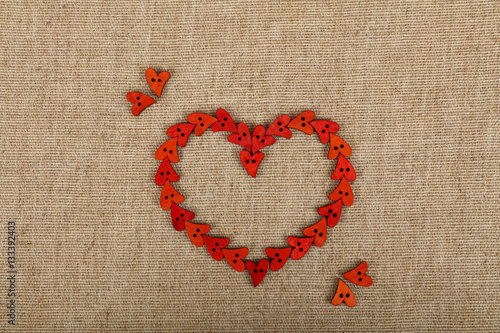 Red heart shaped sewing buttons on canvas