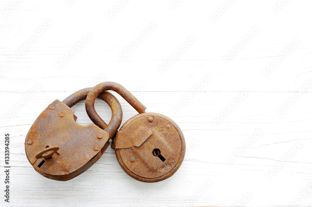 Old rusty padlock on wooden white background Old rusty padlock on wooden white background