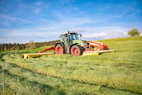 Traktor mit Mähwerk bei der Grasmahd im Allgäu