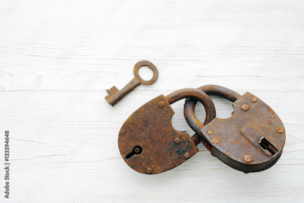 Old rusty padlock on wooden white background Old rusty padlock on wooden white background