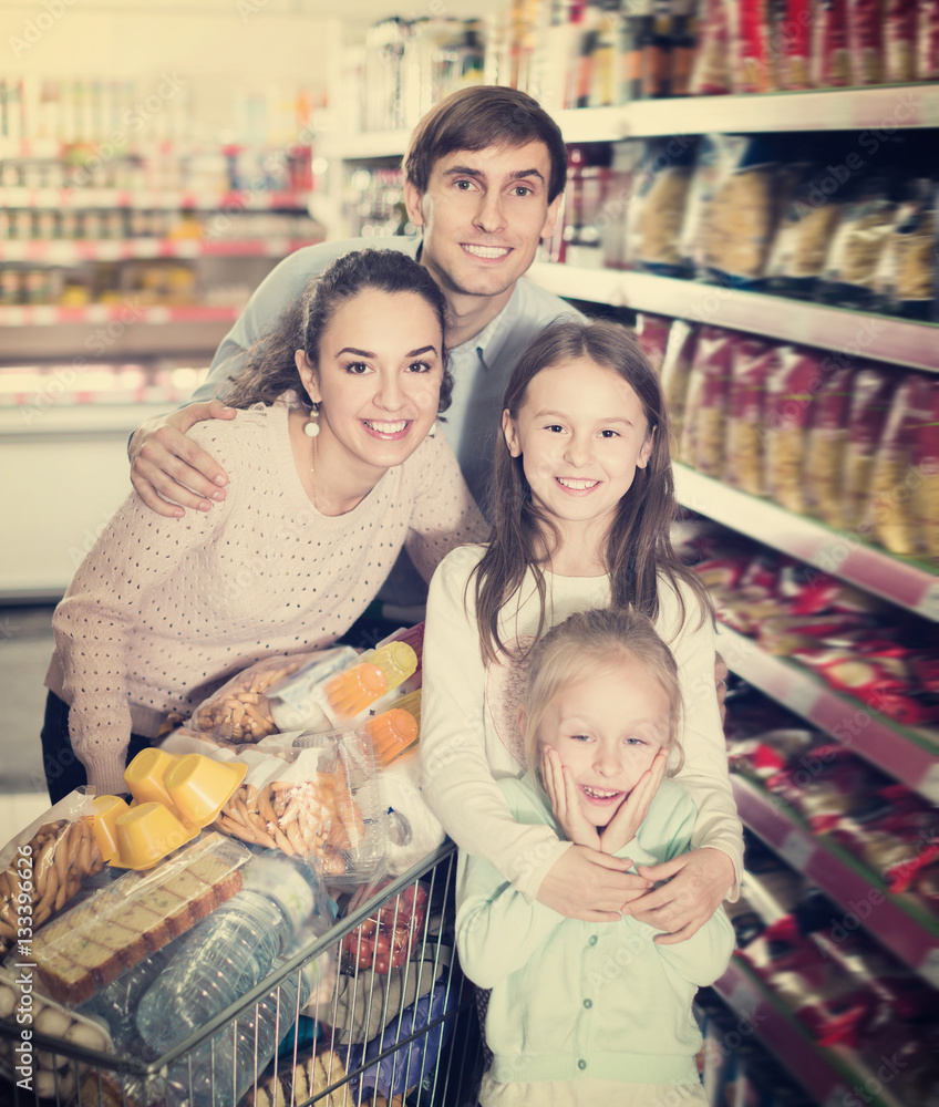 Happy couple with two daughters shopping