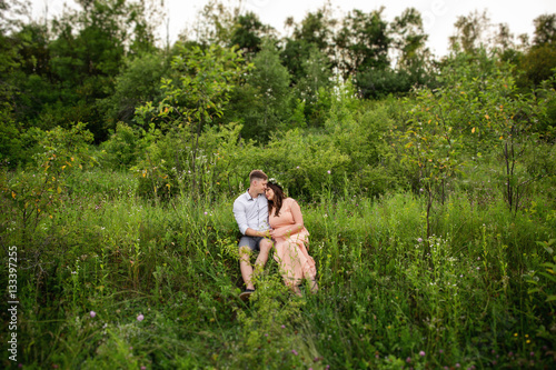 Couple in love sitting on green grass in spring or summer garden. Love and relationship of young couple © Wedding photography
