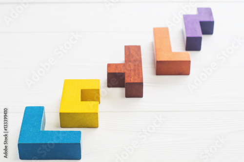 Abstract Background. Different shapes wooden blocks on white wooden background. Geometric shapes in different colors. Concept of creative, logical thinking or problem solving. Copy space.