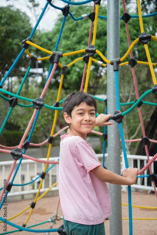 Little boy climbing rope at playground Little boy climbing rope at playground