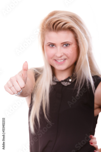 Smiling blonde woman making thumb up gesture