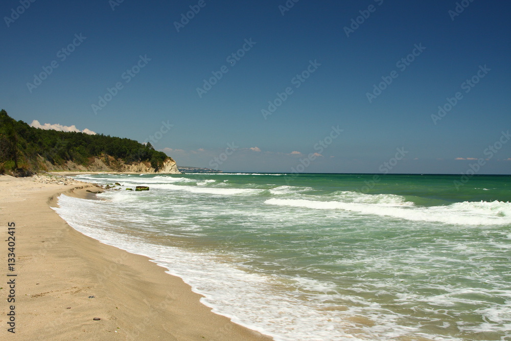 Beautiful sunny beach with blue sky, white waves and golden sand on the Black sea