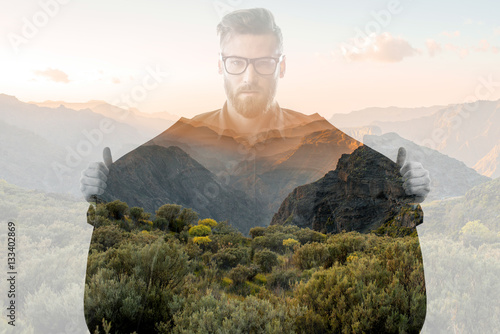 Double exposure portrait of a businessman with jacket combinated with beautiful mountain landscape. Love of nature concept photo