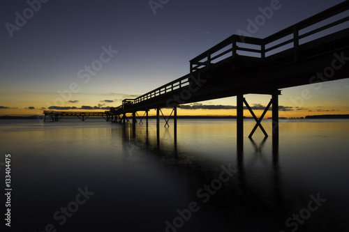 Sunrise with silhouette of an ocean pier and smooth water.Victoria British Columbia.Background © Paul
