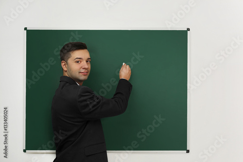Handsome young teacher writ...
