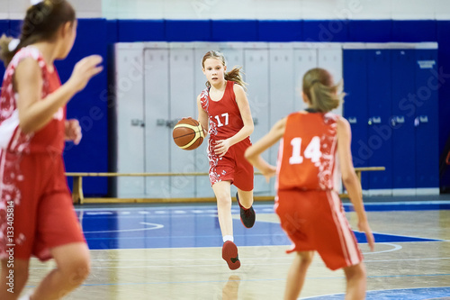 Girls athlete in sport uniform playing basketball