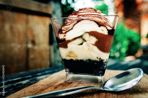 Banoffee pie in a cup on wooden Plate. Delicious dessert. photo