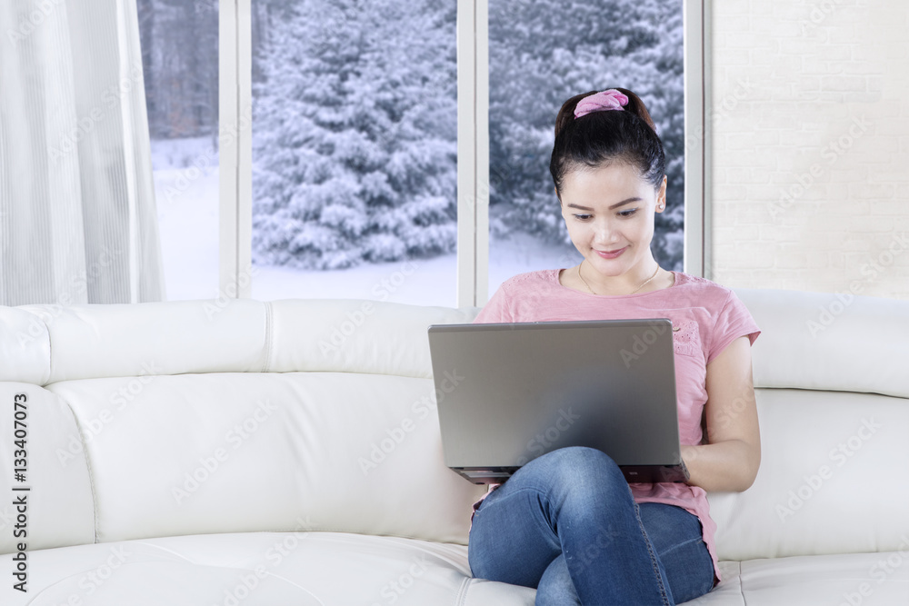 Casual woman uses laptop on couch Casual woman uses laptop on couch
