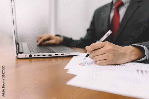 Businessman working with business document and laptop on the table