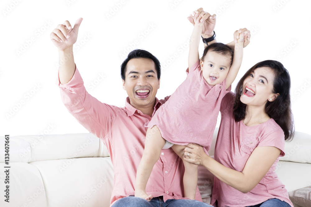 Cute daughter and parents playing on couch