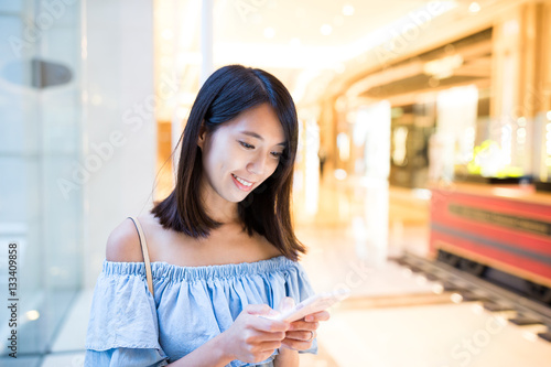 Woman using cellphone at shopping mall