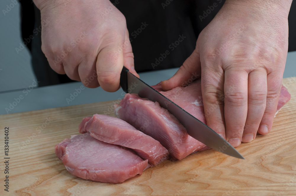 Chef cuts fresh raw pork meat