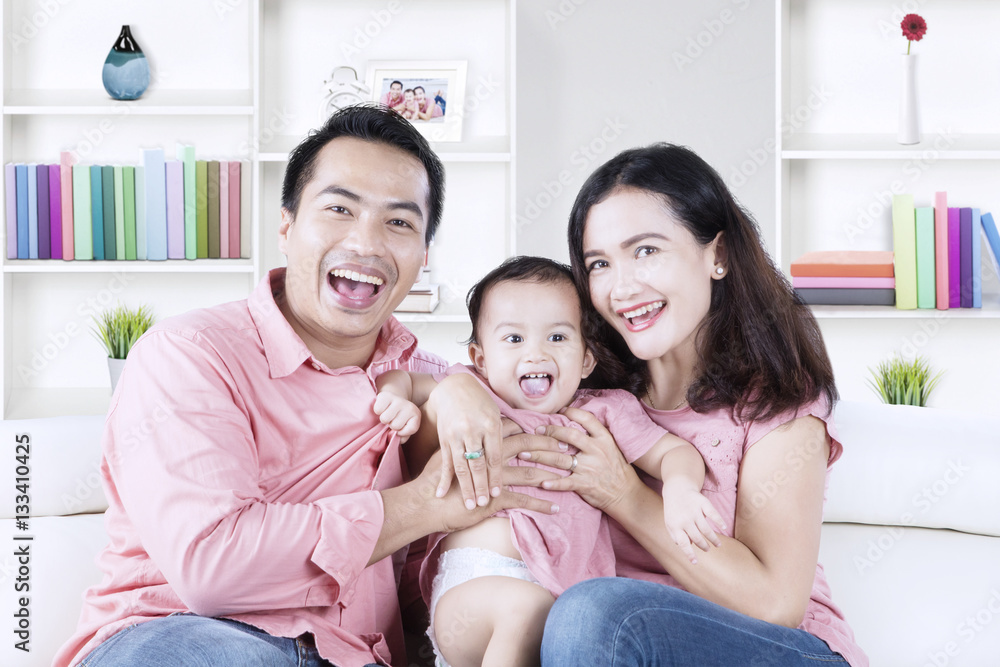 Little girl and parents laughing at home Little girl and parents laughing at home