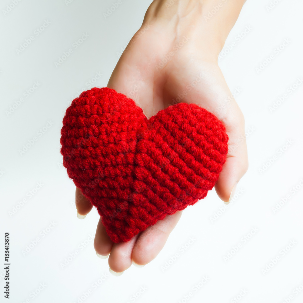 Woman hand holding red crocheted heart. Valentine's Day. Symbol of love. Woman hand holding red crocheted heart. Valentine's Day. Symbol of love.