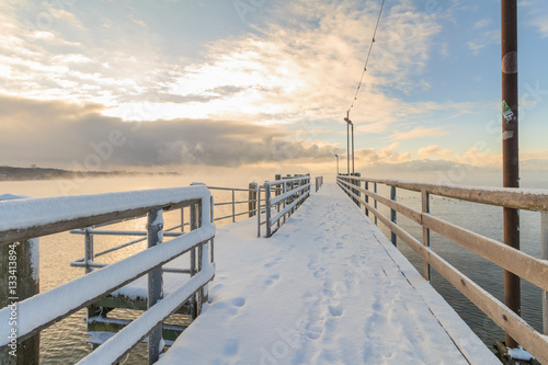 Pier at Lake Chiemsee at Sunrise with fog on water