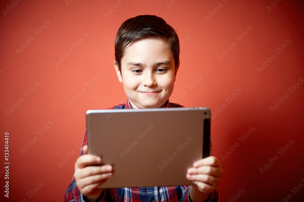Naklejka premium cute boy playing tablet computer