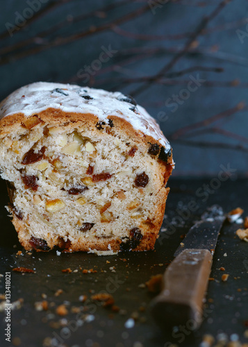 Christmas cake Stollen with raisins, dried apricots and spices on a dark blue background