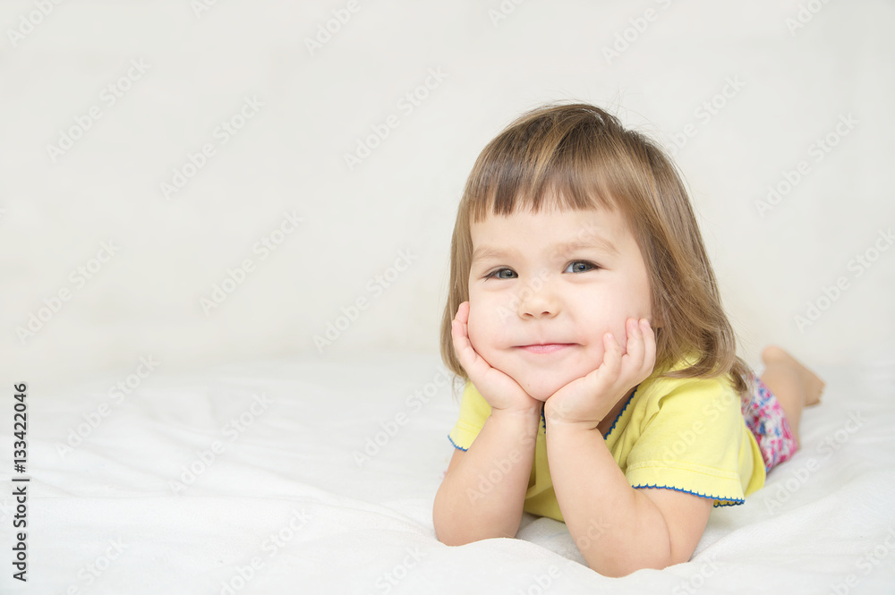 smiling happy little girl lying on bed smiling happy little girl lying on bed