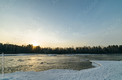 Winter sunset in river.