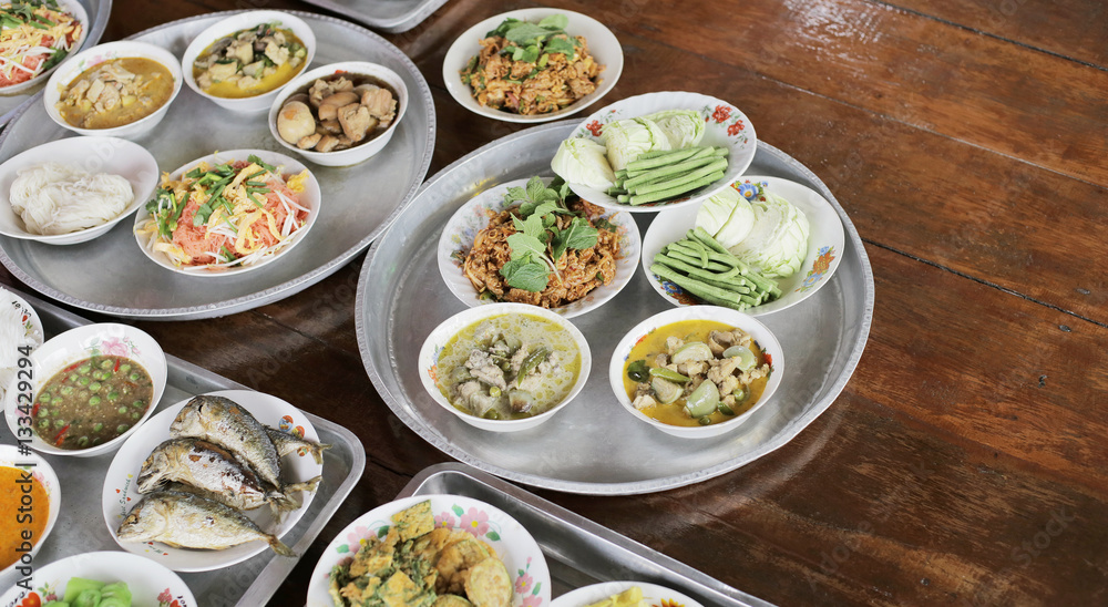 Set of Thai food on tray Fried Mackerel with Shrimp Paste Sauce, Fried Egg with Climbing Wattle, Chicken Green Curry, Spicy minced pork, Noodles rice with curry, Stir-fried noodles on wooden floor Set of Thai food on tray Fried Mackerel with Shrimp Paste Sauce, Fried Egg with Climbing Wattle, Chicken Green Curry, Spicy minced pork, Noodles rice with curry, Stir-fried noodles on wooden floor