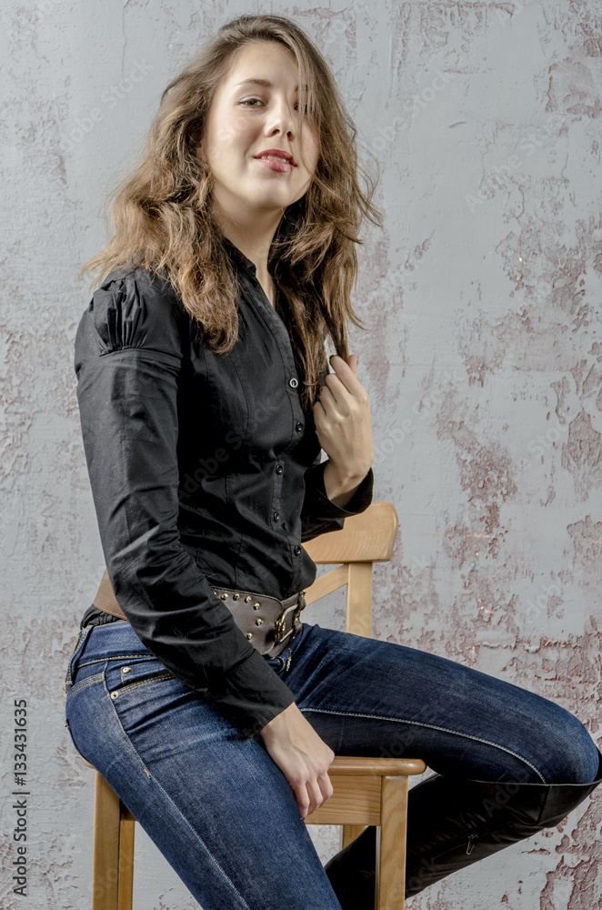 Young girl with curly hair in a black shirt, jeans and high boots cowboy western style
Young girl with curly hair in a black shirt, jeans and high boots cowboy western style